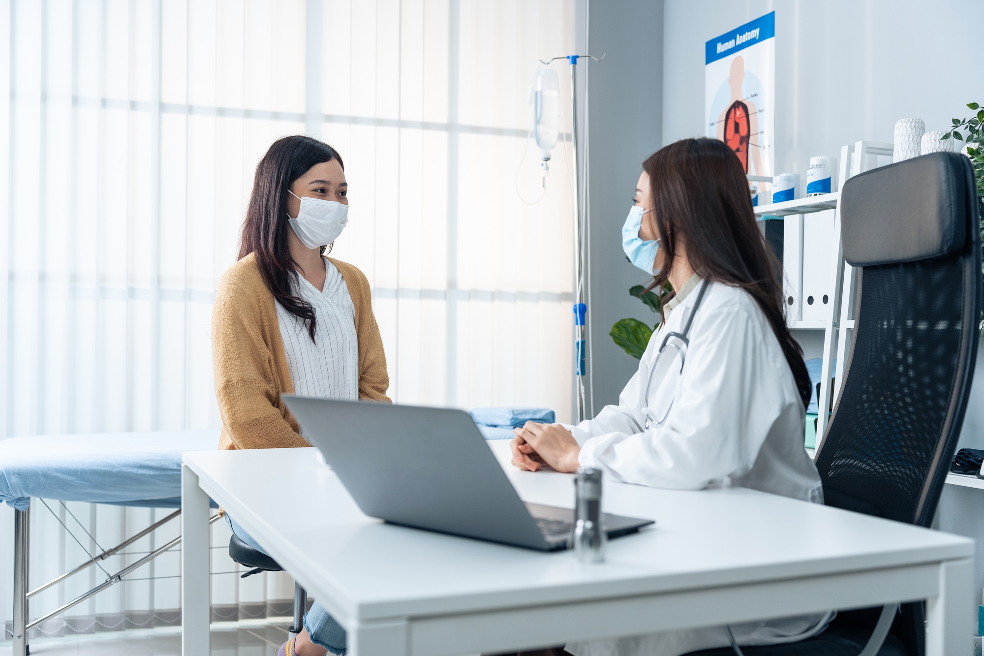Asian specialist woman doctor explain diagnosis to young girl patient.